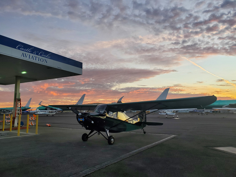 Photo of Norbert the plane, on
the ground at the self-serve fuel pumps, with fading sunset clouds in
the sky