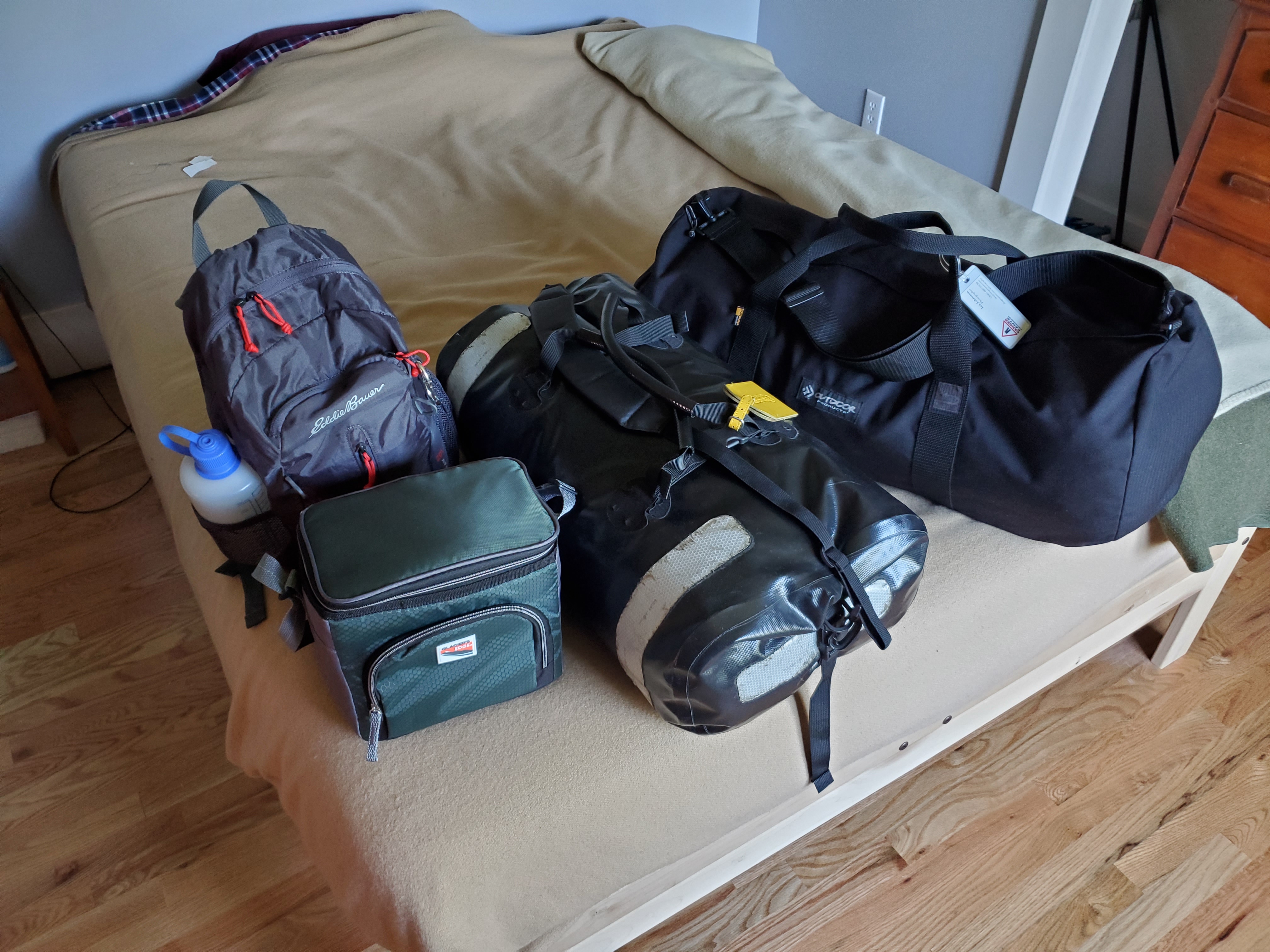 Photo
showing two well-stuffed large duffel bags, a small grey backpack, and
a small rectantular cooler bag