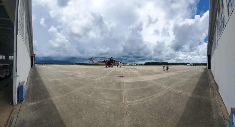 Panoramic
image of an airport ramp.  A huge helicopter sits in the center, while off
to the left is a very dark sky, with pretty puffy clouds from about the
midpoint and to the right.