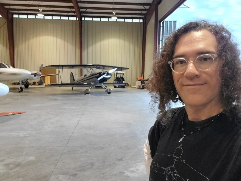 Photo of your author posed with the
biplane inside a hangar.
